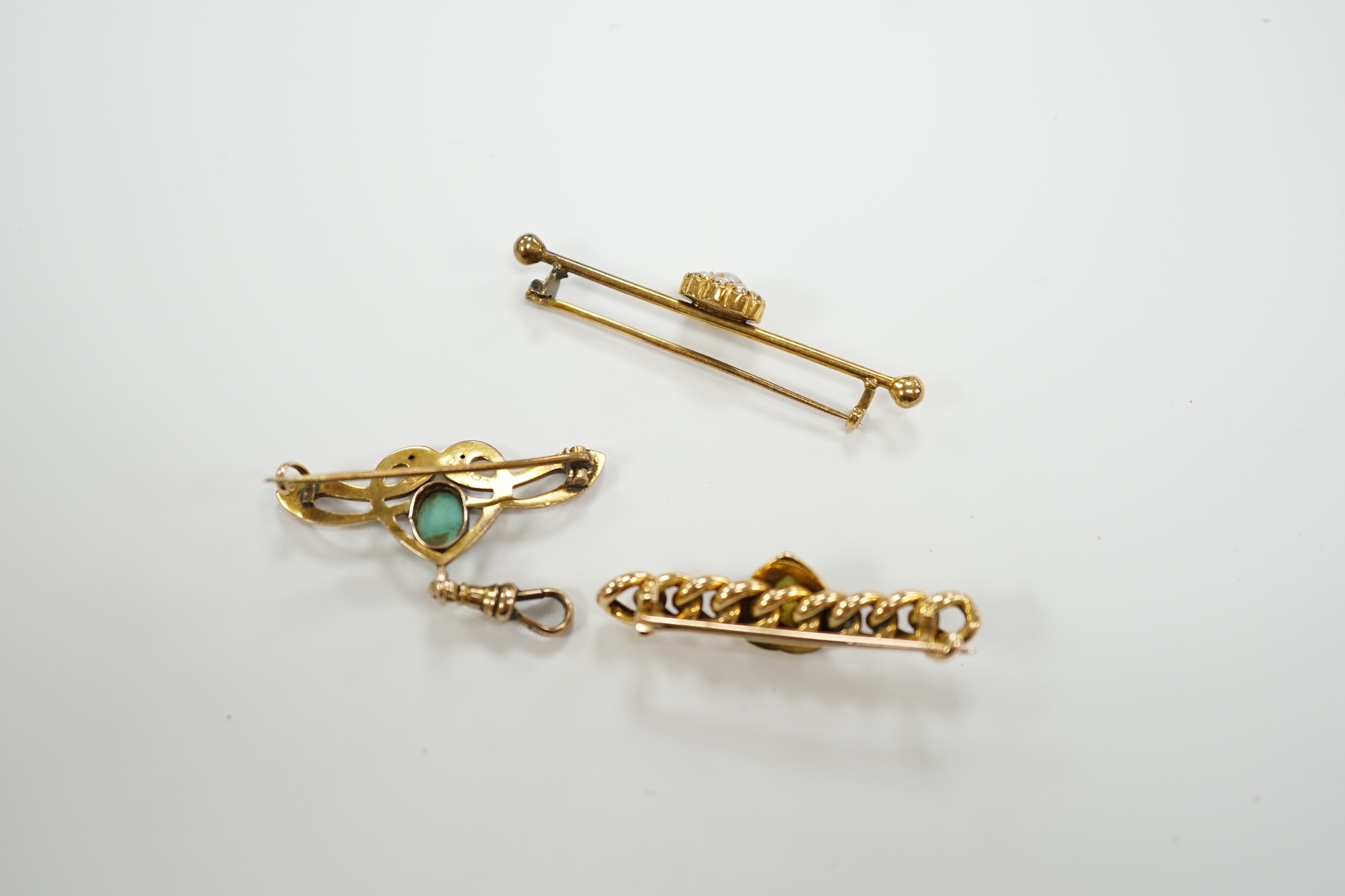 An Edwardian Art Nouveau 9ct gold and turquoise set brooch, width 38mm, a yellow metal (stamped 20) and seed pearl cluster set bar brooch and one other yellow metal and gem set brooch.